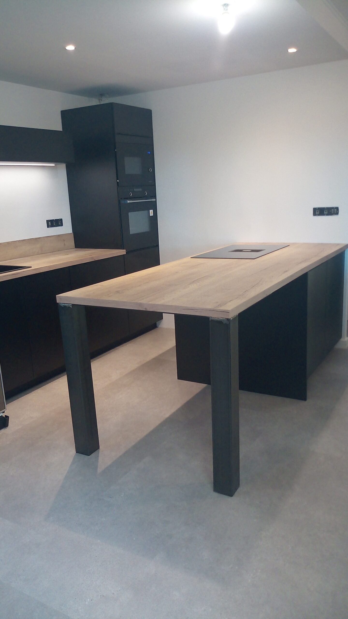 Cuisine noire mate avec grand îlot central – plaque aspirante ROBLIN